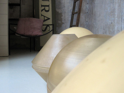 Una pareja de lámparas para colocar a suelo. Piezas geométricas esféricas y trapezoïdal de material de fibra. Piezas recuperades de las antigues faroles de mobiliario urbano